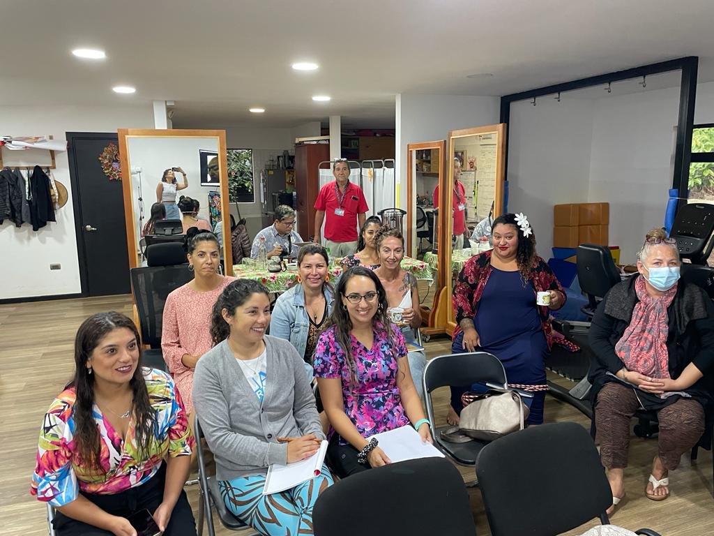 Personas sentadas frente a un proyector viendo la exposición de Carlos Kaiser Director Ejecutivo ONG Inclusiva