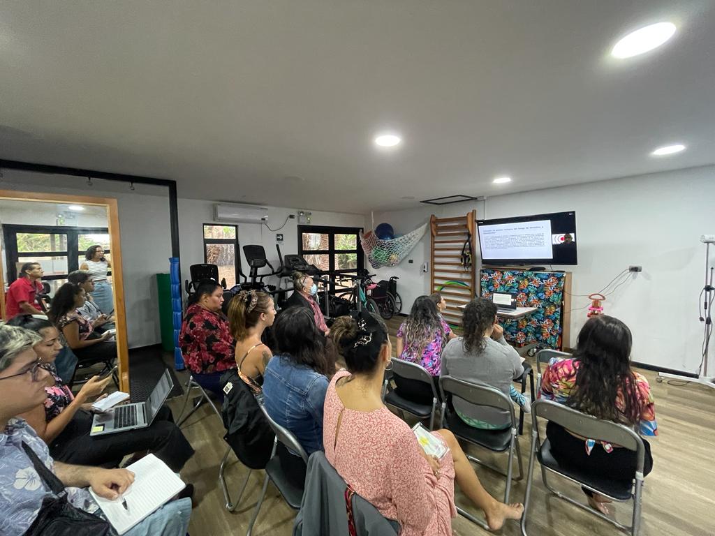 Personas miradas desde la espalda, sentadas frente a un proyector viendo la exposición de Carlos Kaiser Director Ejecutivo ONG Inclusiva